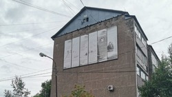 Реклама неизвестных услуг портит фасад пятиэтажного дома в Южно-Сахалинске