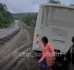 Автобус с пассажирами завис на краю размытой дороги на юге Сахалина
