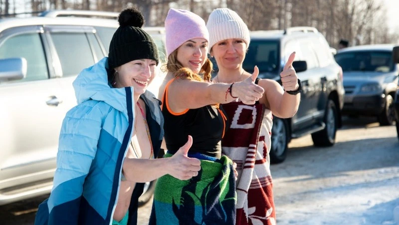 Жители Охи окунулись в прорубь в сильный мороз 