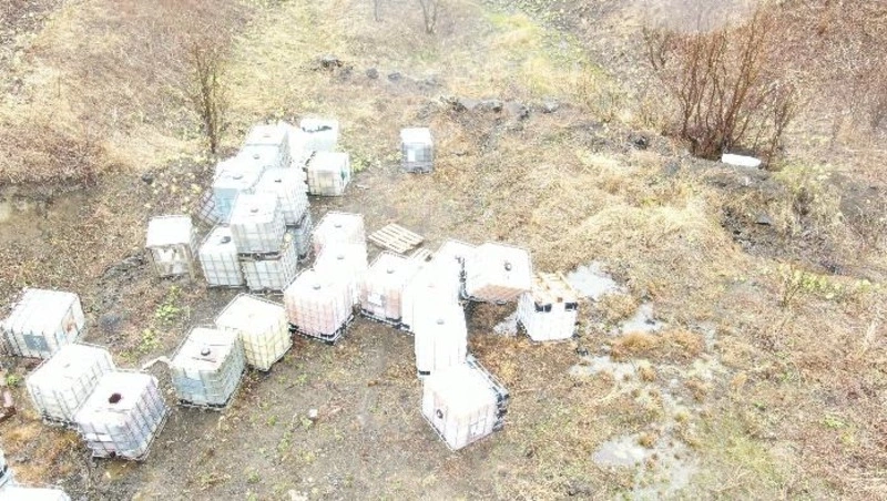 Производственную тару с неизвестным содержимым вывезли с территории родника в Холмске