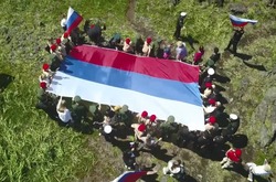 Флаг РФ развернули участники форума «Армия России» у вулкана на Курилах