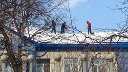 Рабочие без страховки чистили снег с крыши гимназии Южно-Сахалинска