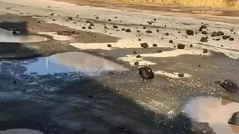 В Аниве вдребезги разбитую автодорогу посыпали крупными кусками угля