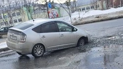 Toyota Prius провалилась в размытую траншею на дороге в Южно-Сахалинске