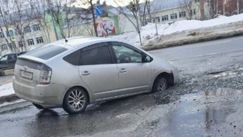 Toyota Prius провалилась в размытую траншею на дороге в Южно-Сахалинске