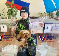 Мальчик с собакой пришел посмотреть процесс голосования на избирательном участке в Шахтерске