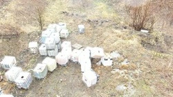 Производственную тару с неизвестным содержимым вывезли с территории родника в Холмске