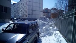 Жители двора в Южно-Сахалинске обходят снежные горы, выходя навстречу машинам