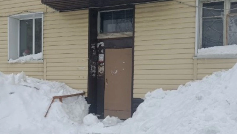 Жительница Долинска пожаловалась на неубранный снег, кучи которого заблокировали подъезд к ее дому