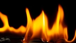 В Холмске внезапно загорелся мусорный бак во дворе жилого дома