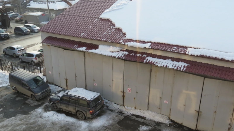 В Южно-Сахалинске сугроб рухнул с крыши на авто