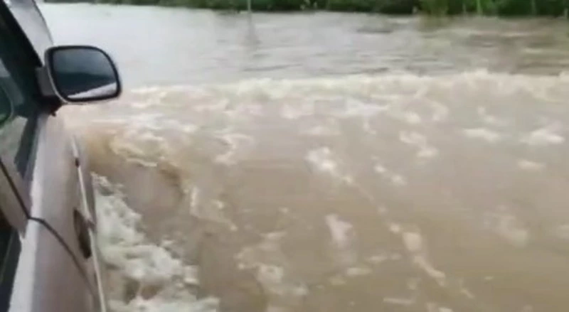 Жители Томаринского района топят автомобили на затопленной дороге